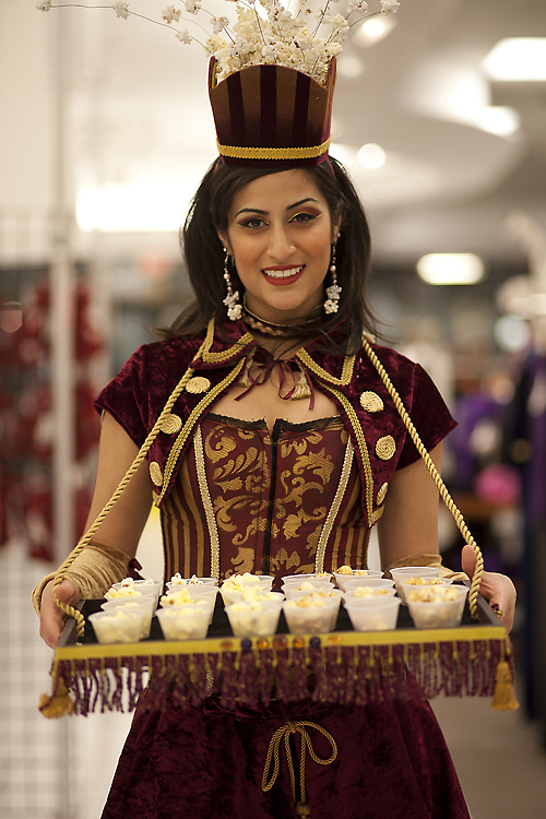 A photo of a woman wearing a costume and serving salads